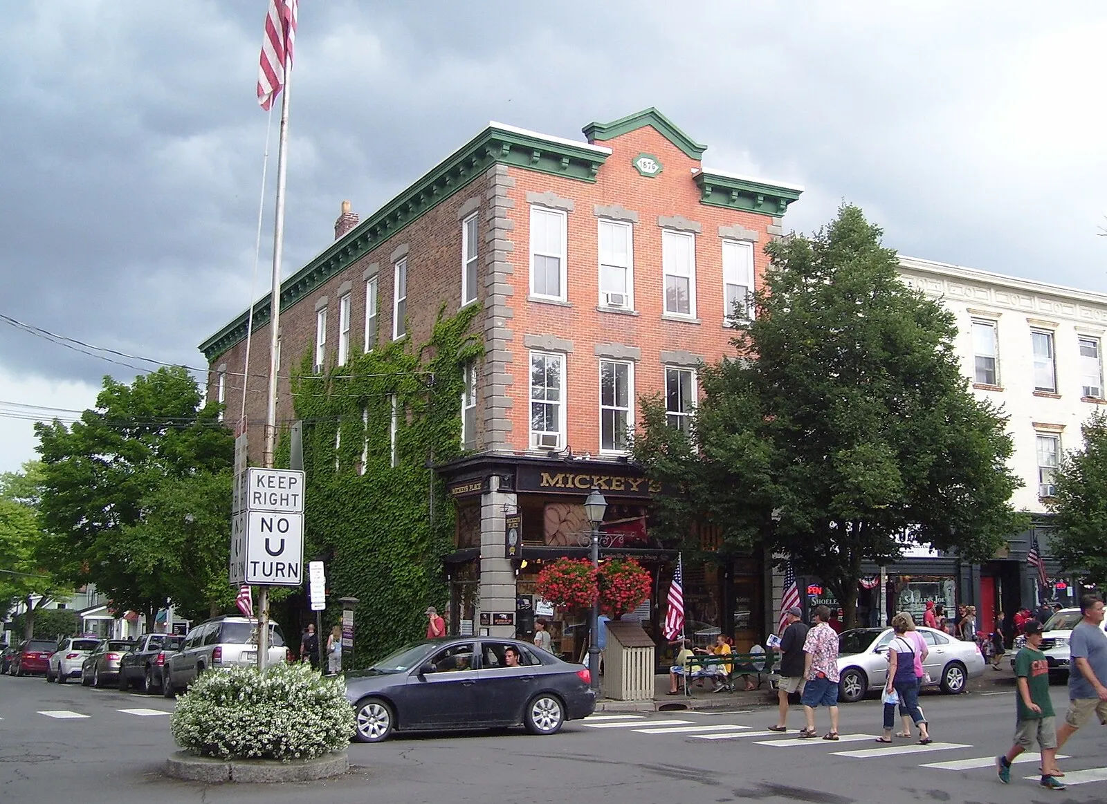 The brick corner block at Main Street and Pioneer Street, Cooperstown, with a flag on the sidewalk