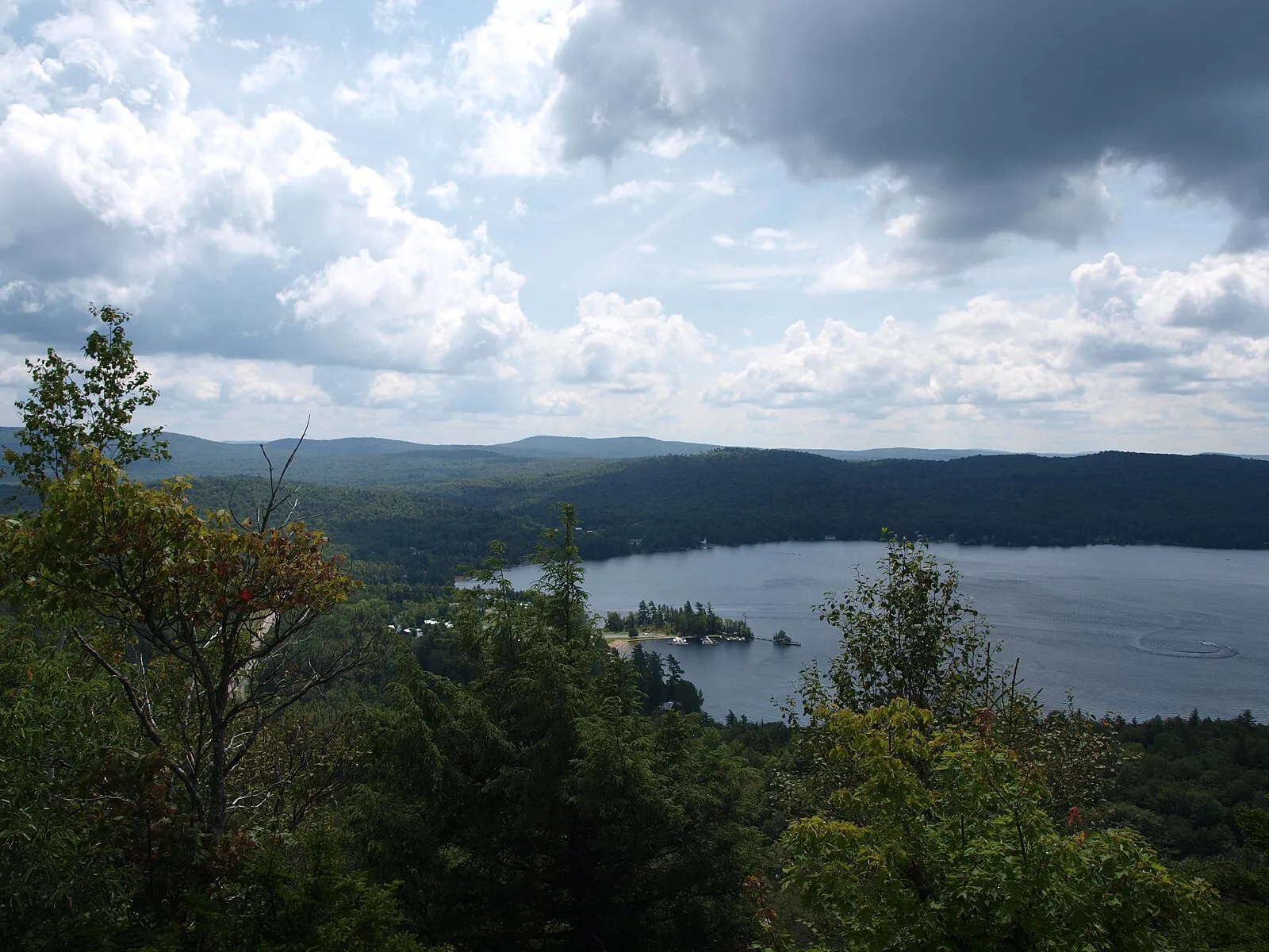 Fourth Lake and the hamlet of Inlet from the Rocky Mountain overlook, under a cloudy August sky