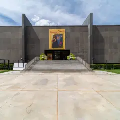 The museum building at Munson, Utica: a granite block on a raised terrace with a broad front stair and an exhibition banner over the entrance
